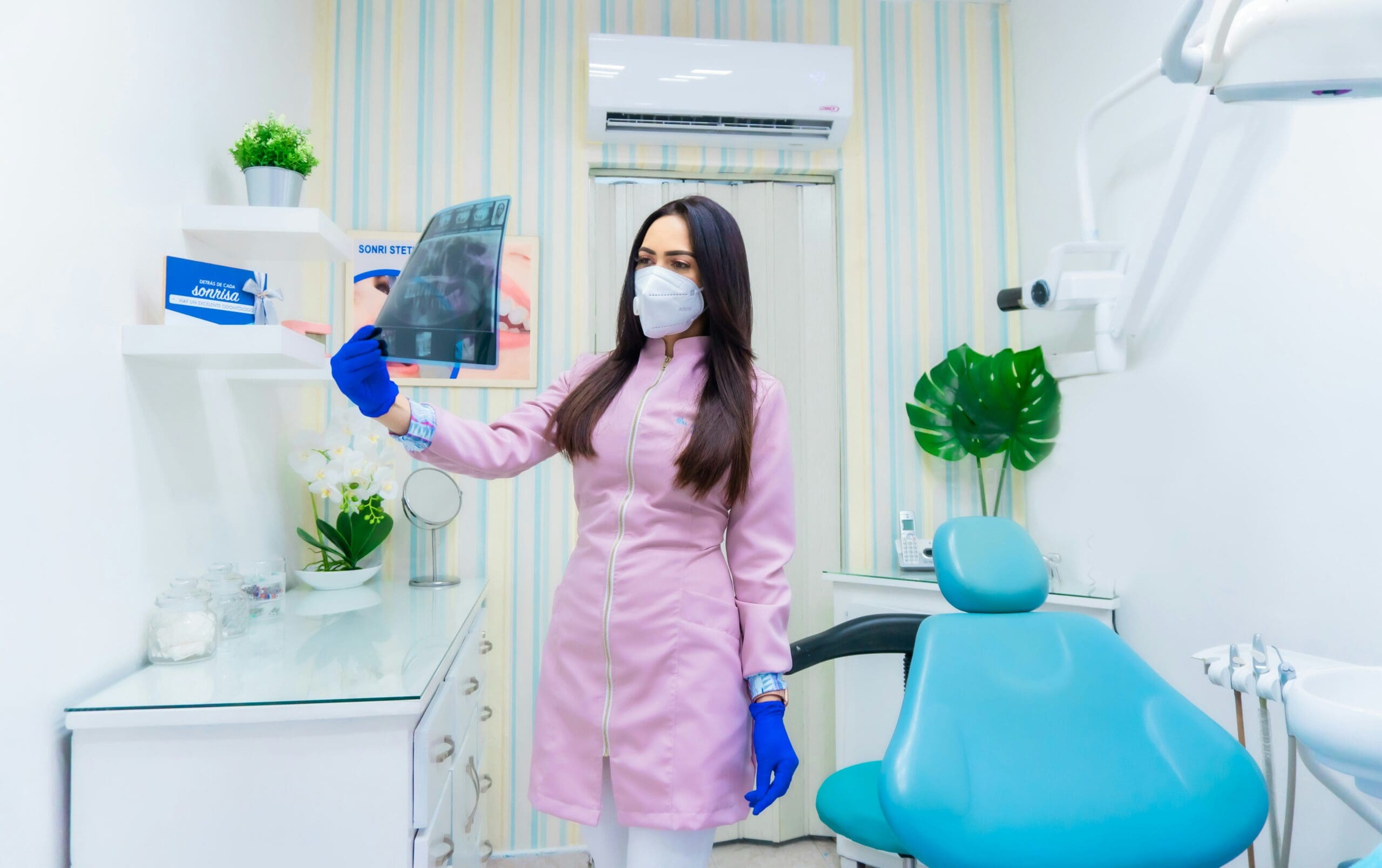 A female dentist reviewing a mouth X-ray on a screen.